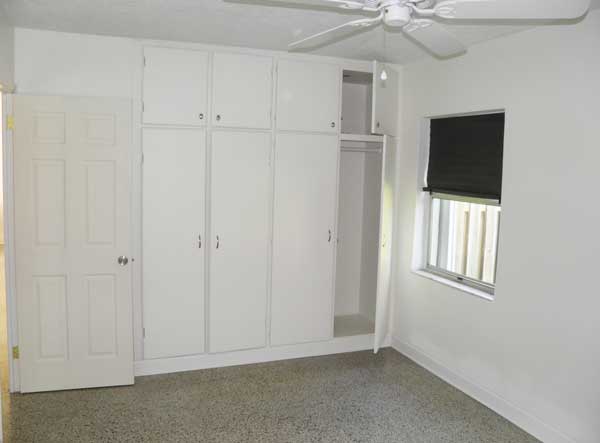 Large bedroom 1 has two windows and wall full of built in closet and storage space.